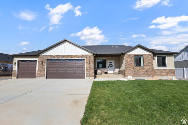 1167 N 150 E Unit 53, Nephi, UT 84648 - view of front of home featuring driveway, fence, a front lawn, an attached garage, and stone siding