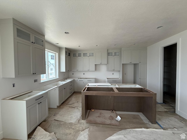 4097 N Ophir Dr, Eagle Mountain, UT 84005 - kitchen with a kitchen island, glass insert cabinets, gray cabinets, and a textured ceiling