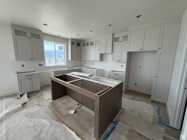 4097 N Ophir Dr, Eagle Mountain, UT 84005 - kitchen with a kitchen island, a textured ceiling, glass insert cabinets, and recessed lighting