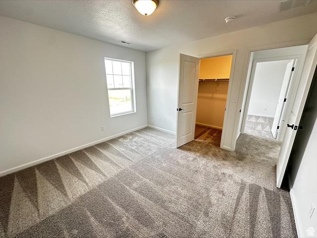 1071 W 400 S Unit 44, Brigham City, UT 84302 - unfurnished bedroom featuring carpet flooring, baseboards, a textured ceiling, a walk in closet, and a closet