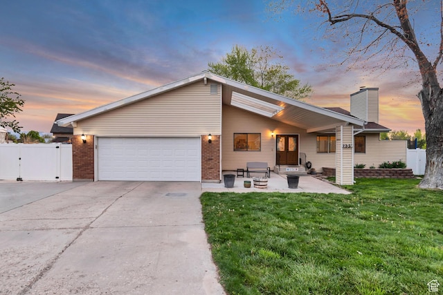 239 Country Club Dr, Stansbury Park, UT 84074 - view of front of home with a garage, a gate, driveway, a chimney, and brick siding