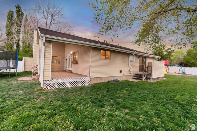 239 Country Club Dr, Stansbury Park, UT 84074 - back of house at dusk with a trampoline and a deck