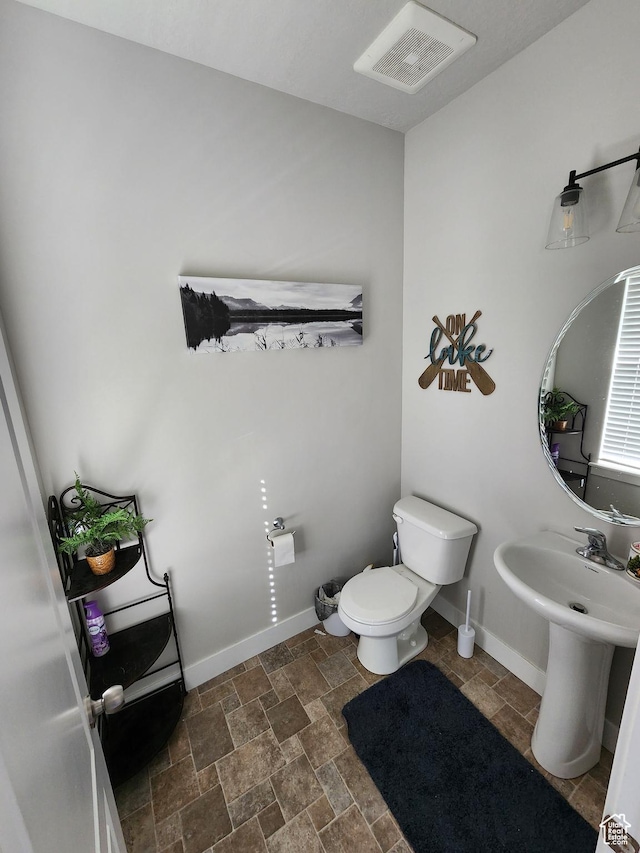 113 N Granite Park Dr, Saratoga Springs, UT 84045 - half bathroom featuring toilet, stone finish flooring, baseboards, and a sink
