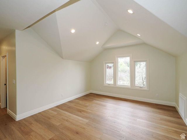 bonus room featuring baseboards, recessed lighting, light wood-style flooring, and lofted ceiling
