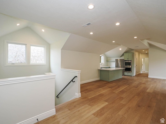 bonus room featuring visible vents, vaulted ceiling, baseboards, recessed lighting, and light wood-style flooring