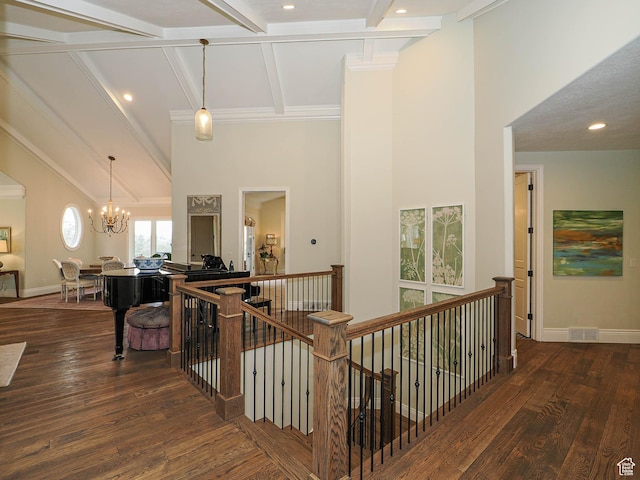 hallway with visible vents, beam ceiling, a notable chandelier, and an upstairs landing
