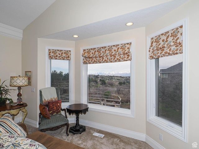 living area featuring visible vents, baseboards, carpet floors, and vaulted ceiling