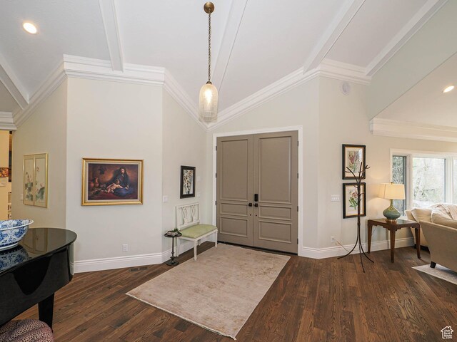 entryway featuring baseboards, ornamental molding, vaulted ceiling with beams, and wood finished floors