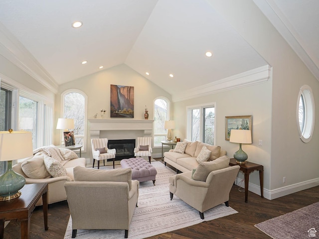 living area with recessed lighting, vaulted ceiling, plenty of natural light, and a glass covered fireplace