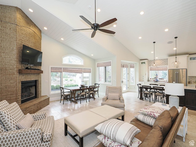 living area featuring baseboards, recessed lighting, a fireplace, and high vaulted ceiling