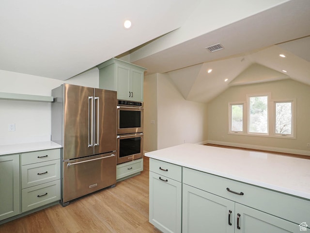 kitchen with appliances with stainless steel finishes, green cabinets, light wood-type flooring, and visible vents