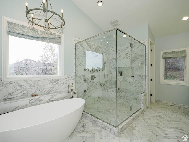 full bathroom featuring a freestanding tub, marble finish floor, a marble finish shower, and a chandelier