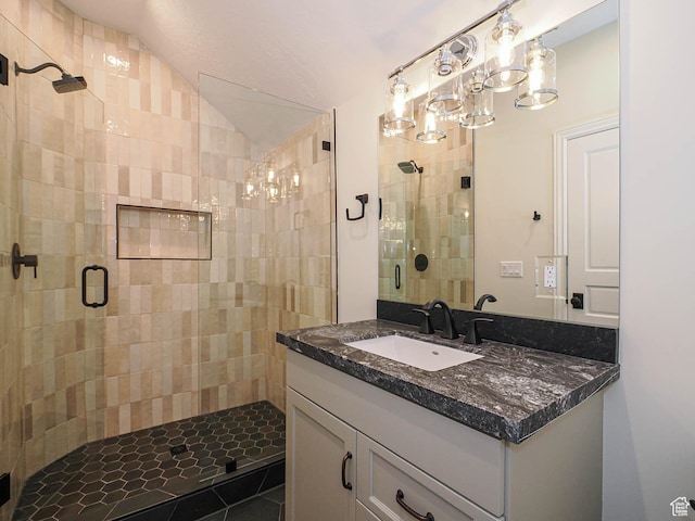 bathroom featuring a shower stall, lofted ceiling, and vanity