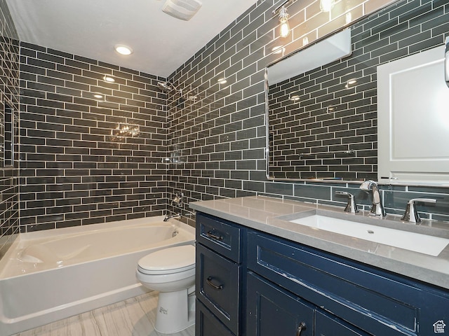 bathroom with vanity, toilet, tile walls, decorative backsplash, and shower / bathing tub combination