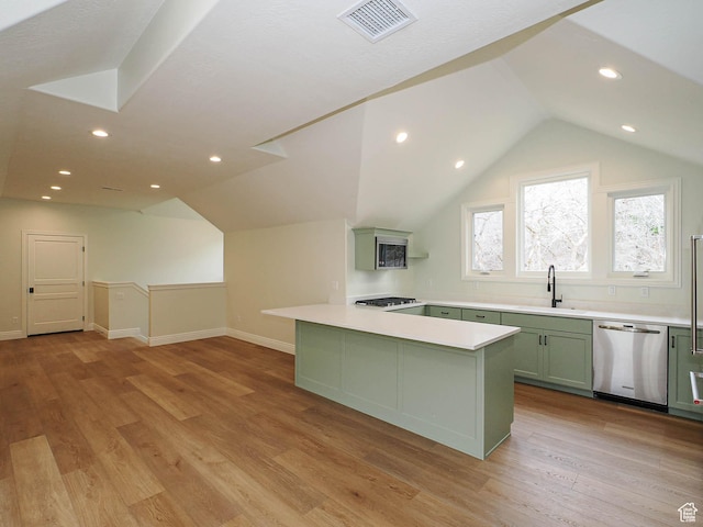 kitchen featuring visible vents, dishwasher, a sink, lofted ceiling, and green cabinetry