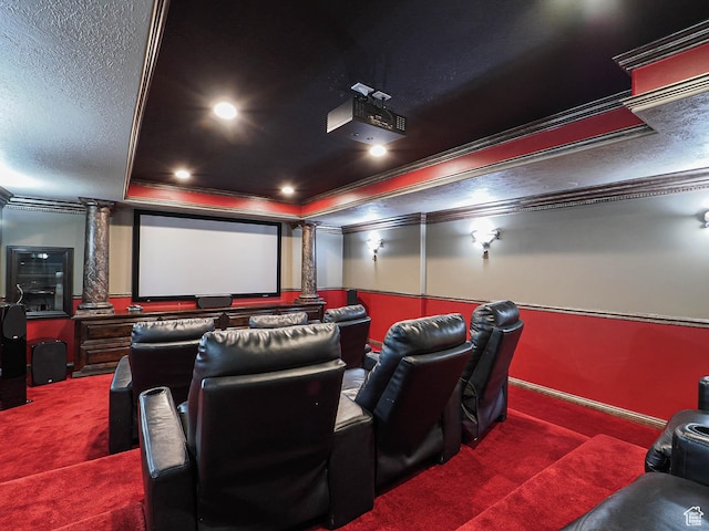 cinema featuring ornate columns, a raised ceiling, carpet, and crown molding