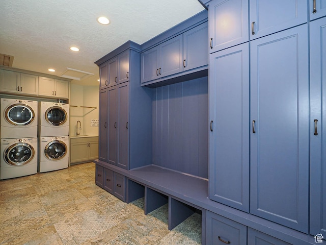 laundry area with independent washer and dryer, cabinet space, stacked washing maching and dryer, a sink, and recessed lighting