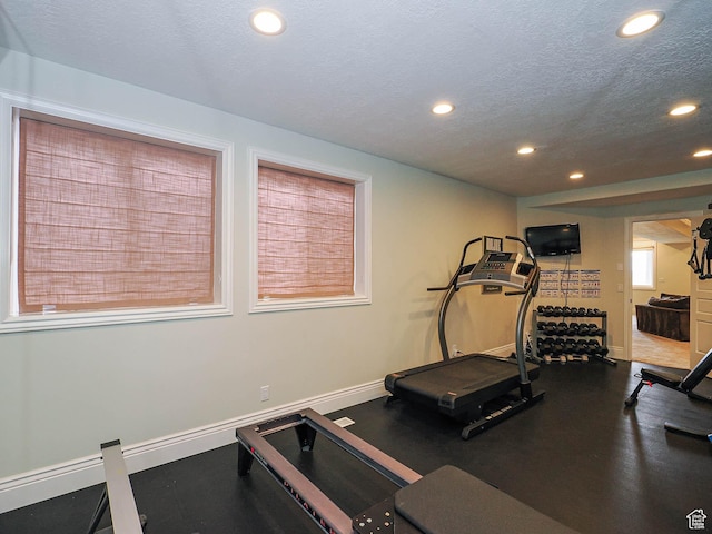 workout room with recessed lighting, baseboards, and a textured ceiling