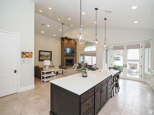 kitchen with a fireplace, a ceiling fan, recessed lighting, and stone tile floors