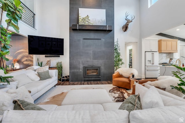 654 N 200 E, American Fork, UT 84003 - living area featuring a tile fireplace, wood finished floors, and a towering ceiling