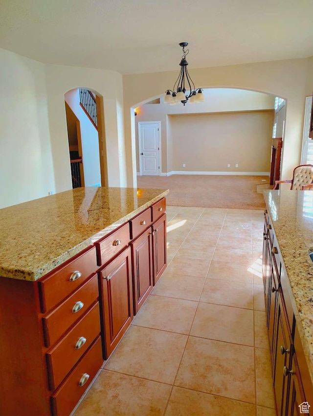 3641 W Canyon Lands Dr, Riverton, UT 84065 - kitchen with light stone counters, arched walkways, light tile patterned floors, a notable chandelier, and hanging light fixtures