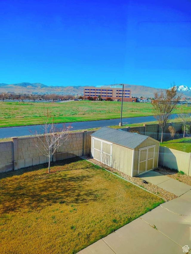 3641 W Canyon Lands Dr, Riverton, UT 84065 - exterior space with a lawn, a mountain view, and a storage unit