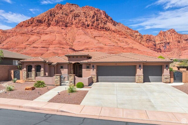 305 E 350 N, Ivins, UT 84738 - view of front of property featuring driveway, a garage, a mountain view, stone siding, and stucco siding