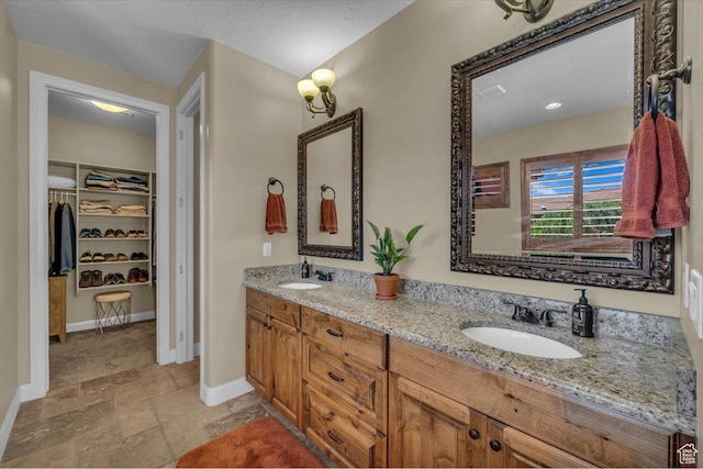 305 E 350 N, Ivins, UT 84738 - bathroom featuring double vanity, a sink, a walk in closet, and stone tile floors