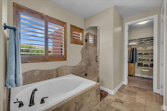 305 E 350 N, Ivins, UT 84738 - full bathroom with a jetted tub, a walk in closet, a shower stall, baseboards, and stone tile flooring