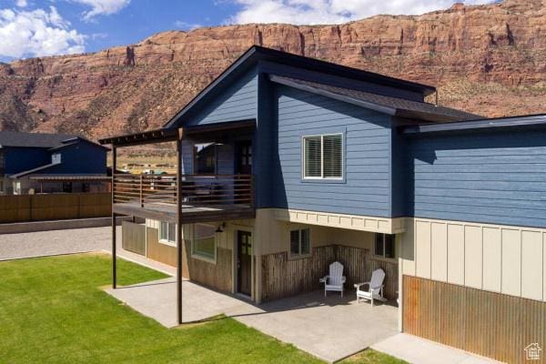 17 Tangren Cir, Moab, UT 84532 - back of property with fence, a mountain view, a yard, and a patio area