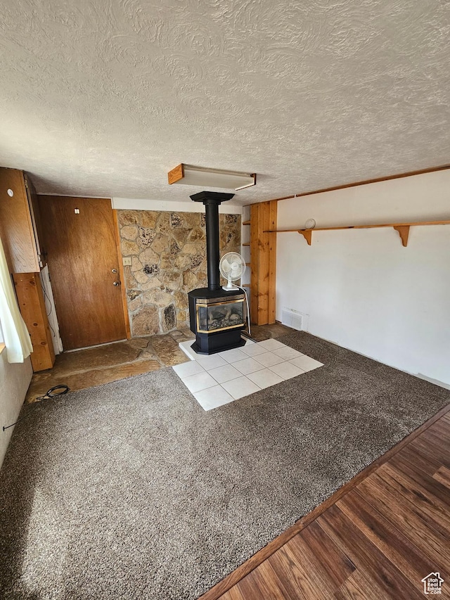 33383 W 8000 S, Duchesne, UT 84021 - unfurnished living room with a wood stove, a textured ceiling, and wood finished floors