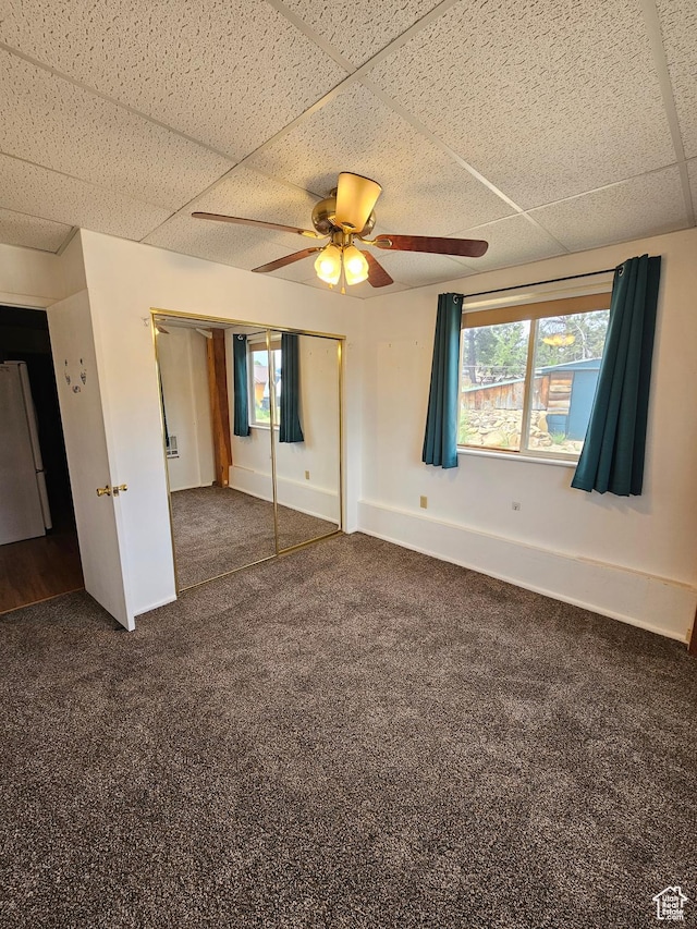 33383 W 8000 S, Duchesne, UT 84021 - unfurnished bedroom featuring freestanding refrigerator, a paneled ceiling, dark carpet, a closet, and baseboards