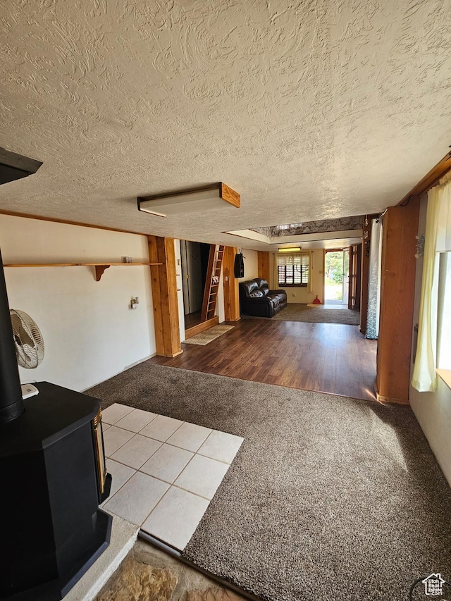 33383 W 8000 S, Duchesne, UT 84021 - unfurnished living room featuring a wood stove, carpet floors, stairway, and a textured ceiling