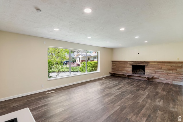 163 E 350 S, Logan, UT 84321 - unfurnished living room with baseboards, a fireplace, dark wood-style floors, and visible vents