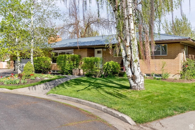 163 E 350 S, Logan, UT 84321 - ranch-style house featuring brick siding, a chimney, a front yard, and metal roof