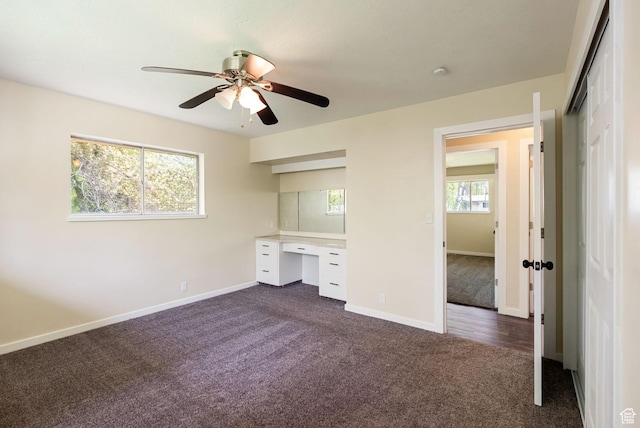 163 E 350 S, Logan, UT 84321 - unfurnished bedroom featuring ceiling fan, built in study area, dark carpet, baseboards, and a closet