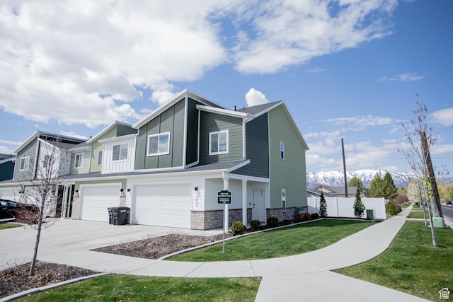 1809 S 1280 W, Logan, UT 84321 - view of side of property with fence, stone siding, a garage, concrete driveway, and a yard