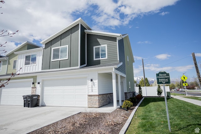 1809 S 1280 W, Logan, UT 84321 - view of side of home with a lawn, fence, concrete driveway, an attached garage, and stone siding