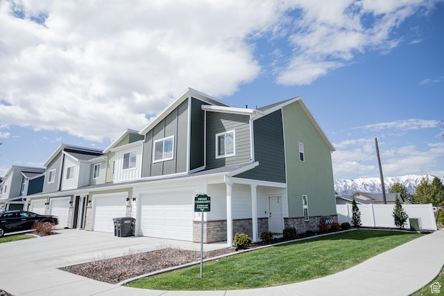 1809 S 1280 W, Logan, UT 84321 - view of front of property featuring driveway, a garage, fence, a front lawn, and stone siding