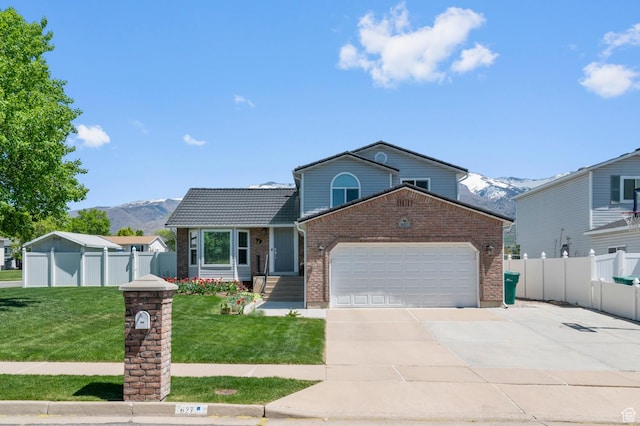 627 S 825 E, Layton, UT 84041 - view of front facade with brick siding, fence, a mountain view, and a garage