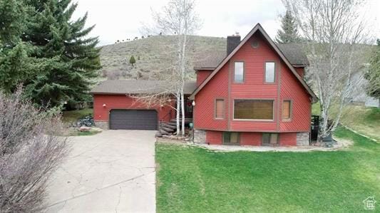1752 Cedar View Rd, Soda Springs, ID 83276 - view of front facade featuring concrete driveway, a chimney, a front yard, and a garage