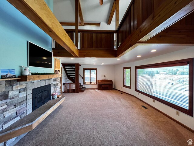 1752 Cedar View Rd, Soda Springs, ID 83276 - unfurnished living room featuring carpet floors, stairs, a stone fireplace, beam ceiling, and recessed lighting