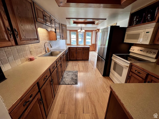 1752 Cedar View Rd, Soda Springs, ID 83276 - kitchen featuring white appliances, a sink, light wood-type flooring, a tray ceiling, and decorative backsplash