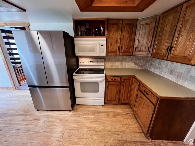 1752 Cedar View Rd, Soda Springs, ID 83276 - kitchen featuring white appliances, brown cabinets, backsplash, and light wood-style floors