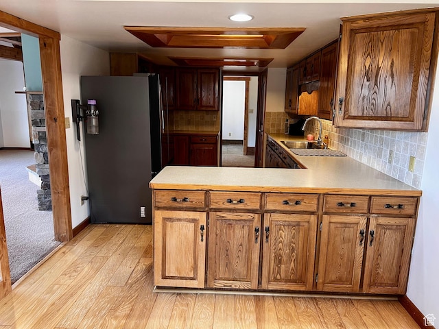 1752 Cedar View Rd, Soda Springs, ID 83276 - kitchen featuring freestanding refrigerator, a sink, light wood-style flooring, a peninsula, and brown cabinetry