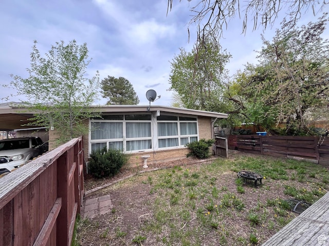 3766 S Orchard Ave E, South Ogden, UT 84403 - back of property with brick siding, fence, and a fire pit