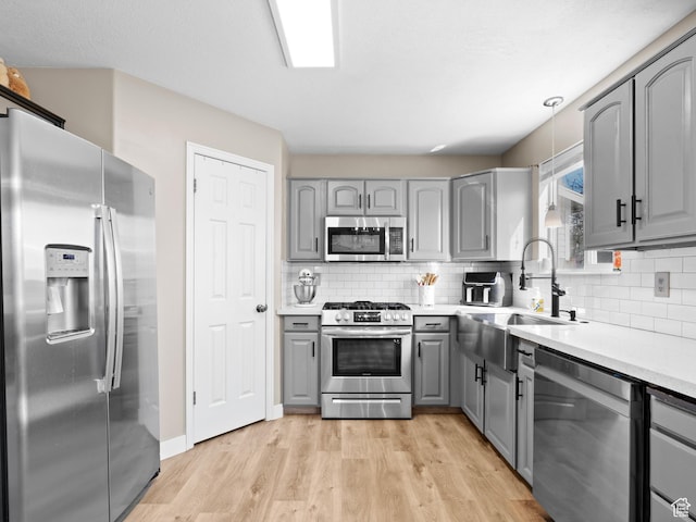 1415 S Bridgeview Dr W, Layton, UT 84041 - kitchen with stainless steel appliances, gray cabinetry, a sink, and light wood-type flooring