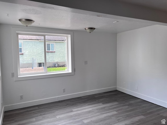 172 N 300 W, Logan, UT 84321 - unfurnished room with baseboards, a textured ceiling, and wood finished floors