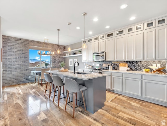 2813 W Hidden Moose Ln, Lehi, UT 84043 - kitchen featuring light wood-type flooring, a sink, appliances with stainless steel finishes, and brick wall