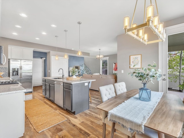 2813 W Hidden Moose Ln, Lehi, UT 84043 - kitchen featuring light stone countertops, light wood-type flooring, recessed lighting, a sink, and stainless steel appliances